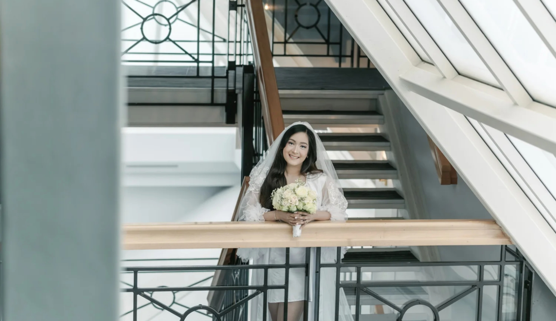 Bride smiling on a bright staircase before her ceremony